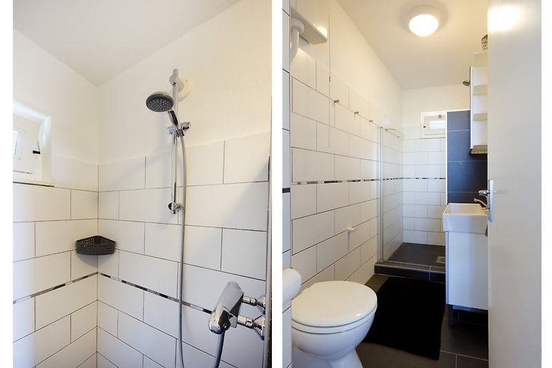 Prachtige badkamer met zwarte en paarse accenten, moderne inrichting en glazen douchewand.