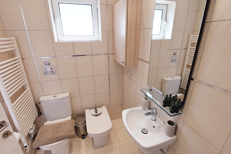 Piękna łazienka z fioletowymi płytkami, lustrem i umywalką.