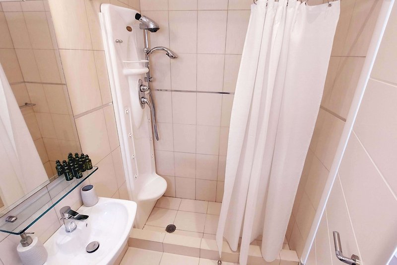 Piękna łazienka z fioletowymi płytkami i prysznicem.