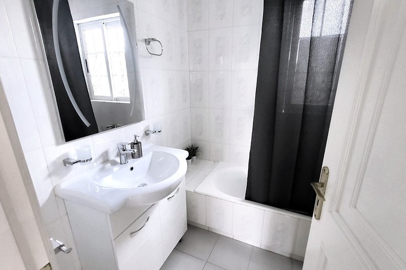 Piękna łazienka z lustrem, umywalką i stylowymi armaturami.