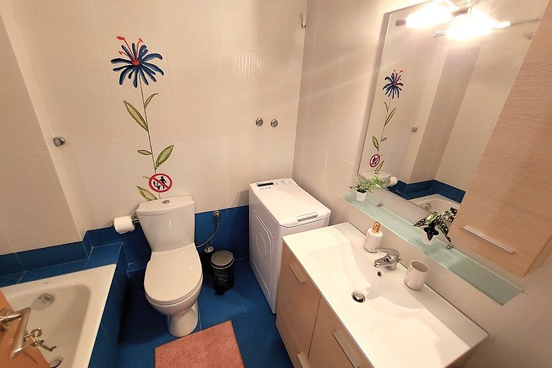 Pięknie urządzone wnętrze łazienki z fioletowymi dodatkami.