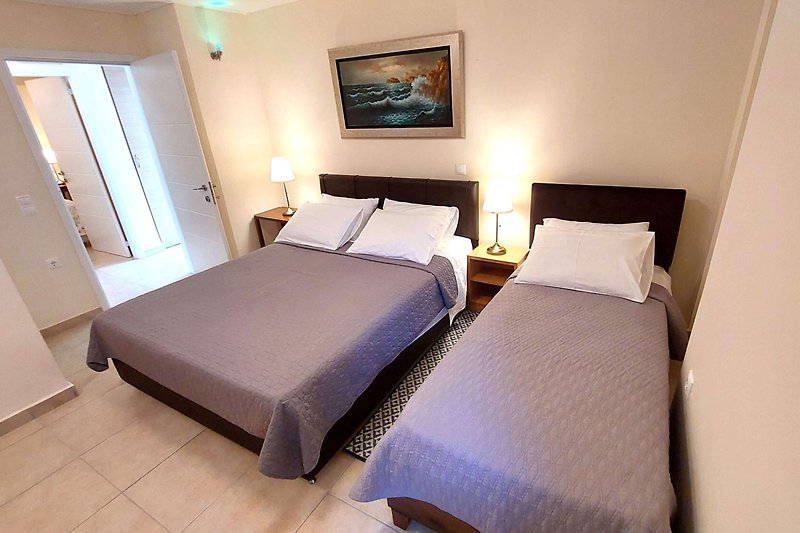 Komfortowa sypialnia z drewnianym łóżkiem i stylowym oświetleniem.