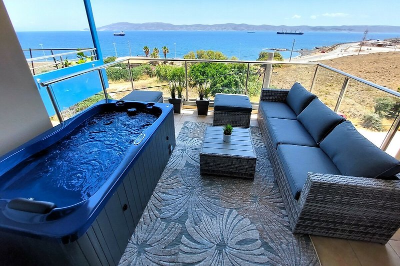 Piękny widok na morze, luksusowe meble na zewnątrz, relaksujący odcień błękitu.