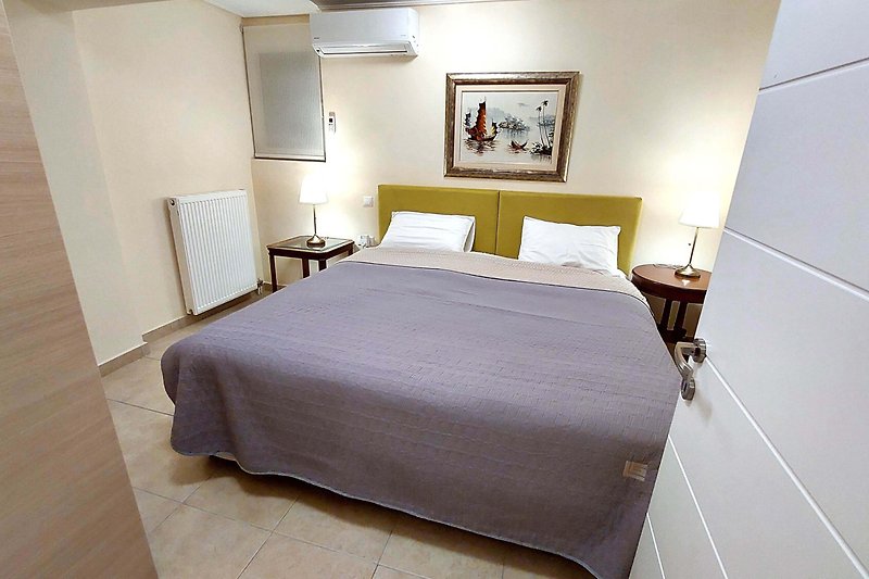 Komfortowa sypialnia z drewnianym łóżkiem i stylowym oświetleniem.