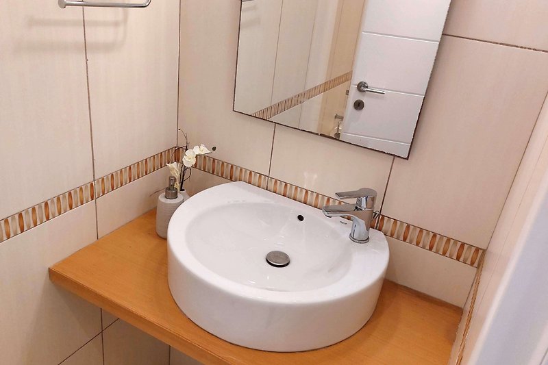 Piękna łazienka z designerską umywalką i lustrem.