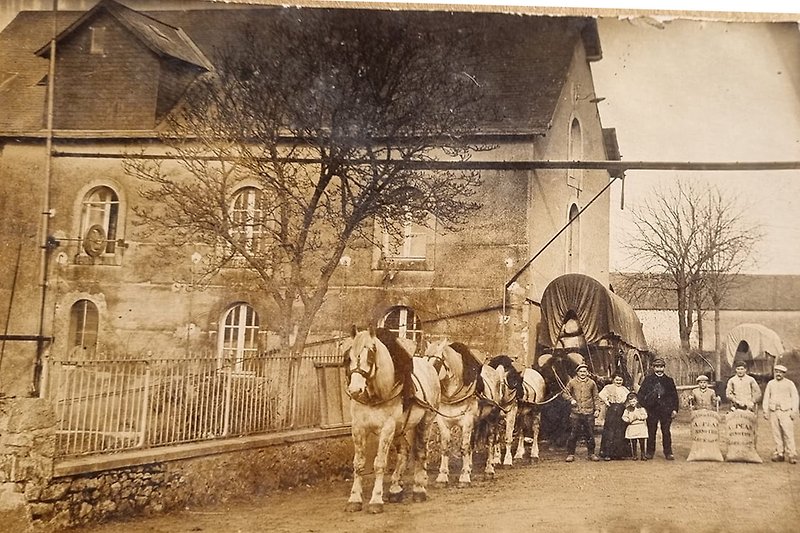 Die Müllerfamlile vor dem historisches Haus mit einem Pferdewagen
