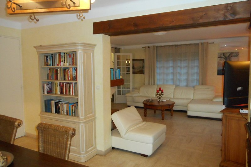 Gemütliches Wohnzimmer mit bequemer Couch, Holzmöbeln und stilvoller Beleuchtung.