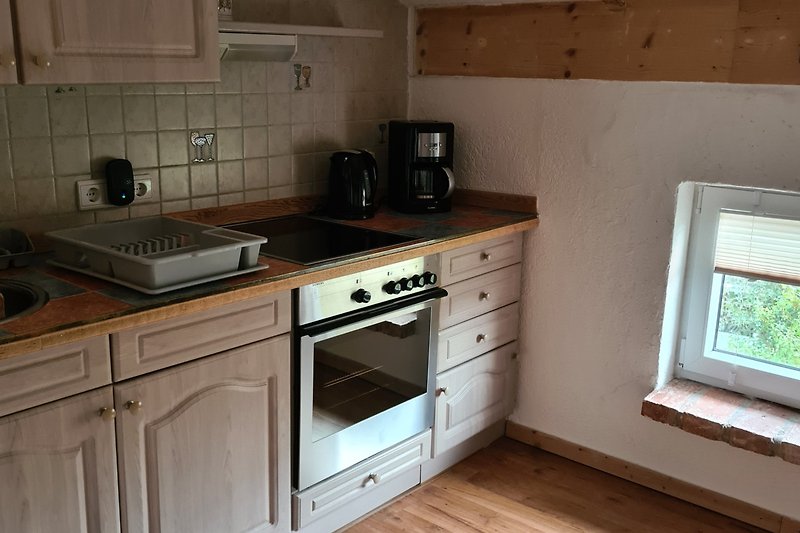 Moderne Küche mit Holzschränken, Granit und Gasofen.