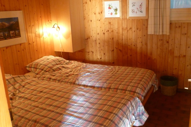 Gemütliches Schlafzimmer mit stilvollem Holzmöbel und gemütlicher Beleuchtung.