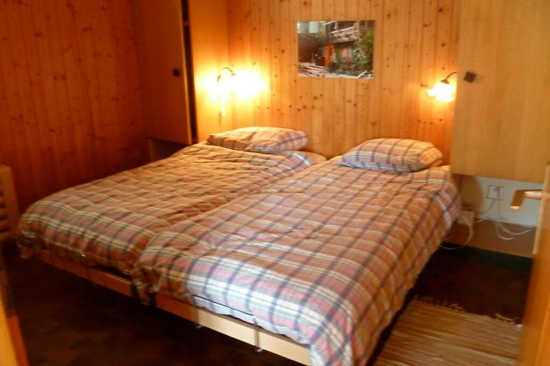 Gemütliches Schlafzimmer mit bequemem Bett und stilvollem Holzmöbel.
