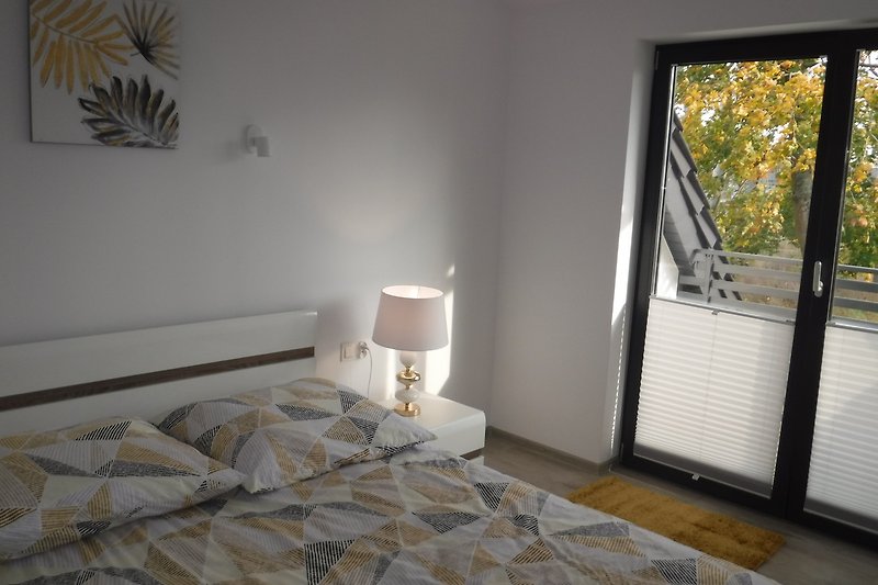 Modernes Schlafzimmer mit elegantem Bett, Kunst an den Wänden und stilvoller Einrichtung.