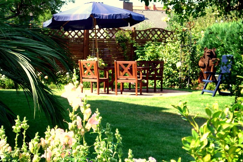 Garten für Gäste mit  Sitzgruppe, Grill und hoher Hecke