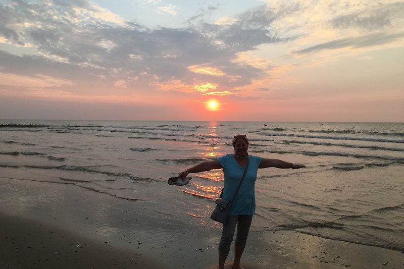 Frei sein am Meer beim Sonnenuntergang