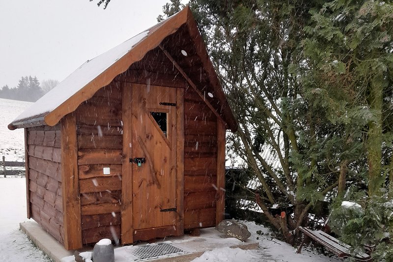 Sauna Haus im verschneitem Garten