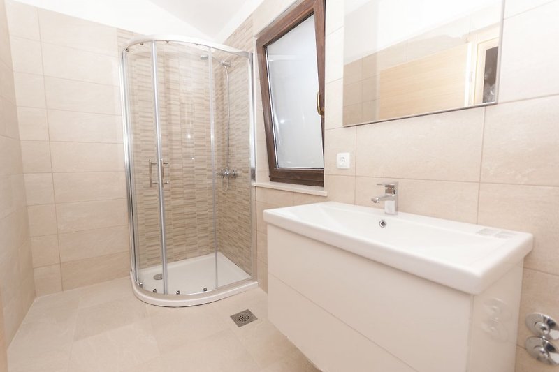 Das Badezimmer besticht durch sein elegantes Design und bietet eine harmonische Atmosphäre für erfrischende Momente