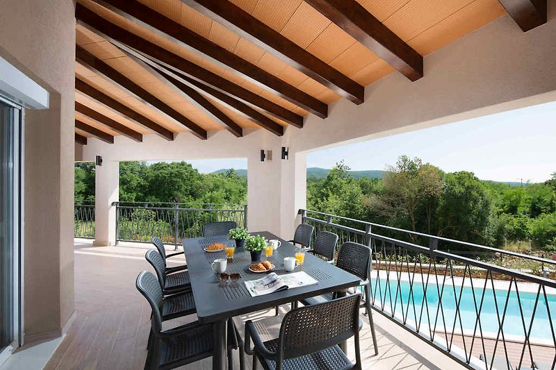 First floor terrace overlooking the pool and surrounding nature.