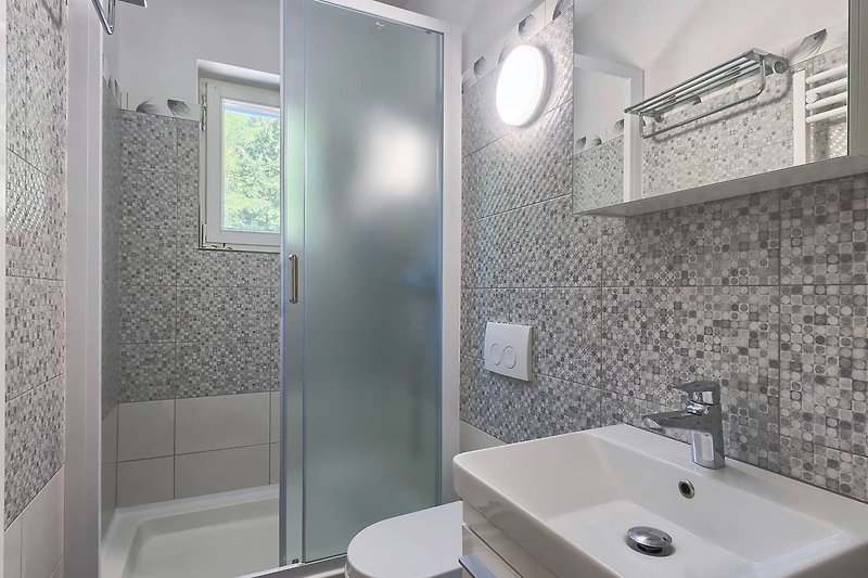Modernes Badezimmer mit Glasdusche und elegantem Design.