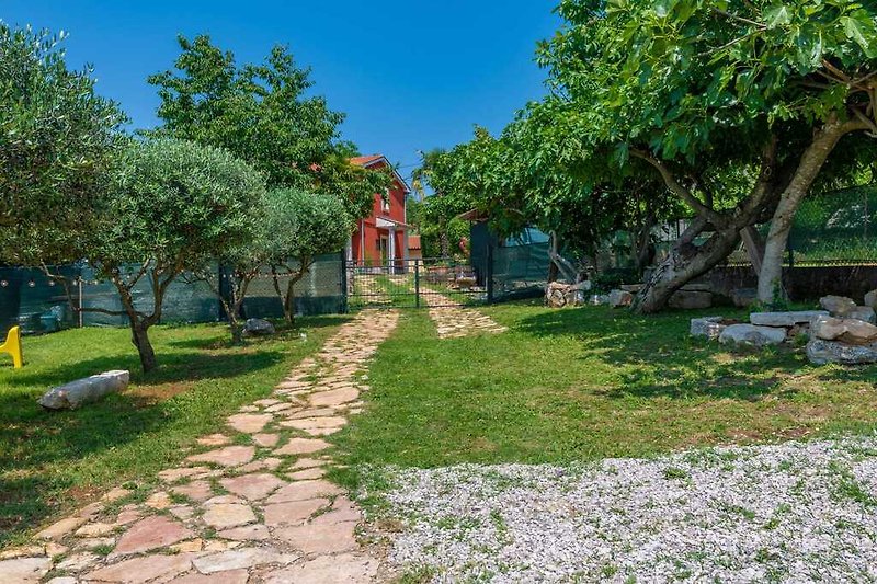 Spazieren Sie entlang des gepflasterten Weges im bezaubernden Garten von Villa Casa di Nonna Ida.