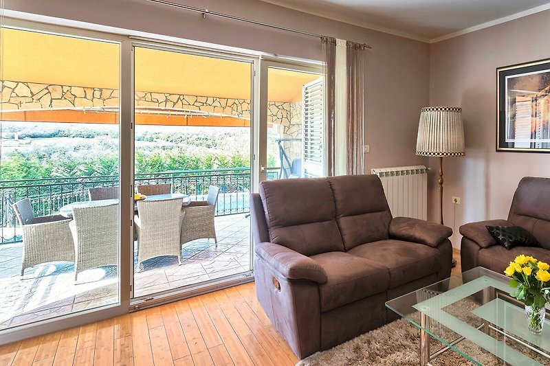 Die Glastür im Wohnzimmer bietet Ihnen einen schnellen Zugang zur Terrasse und sorgt für viel natürliches Licht
