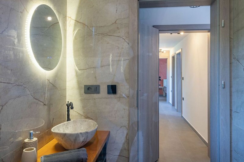 Spiegel mit Hintergrundbeleuchtung lässt dieses Bad erstrahlen