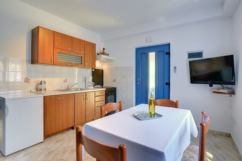 The dining area and kitchen are equipped with all necessary amenities.