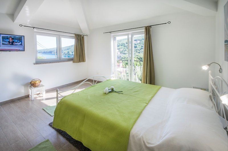 Comfortable bedroom with double bed and single bed - with sea view.