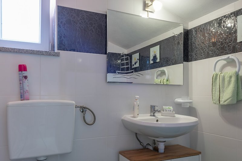 Ein modernes Badezimmer mit Waschbecken und Spiegel.