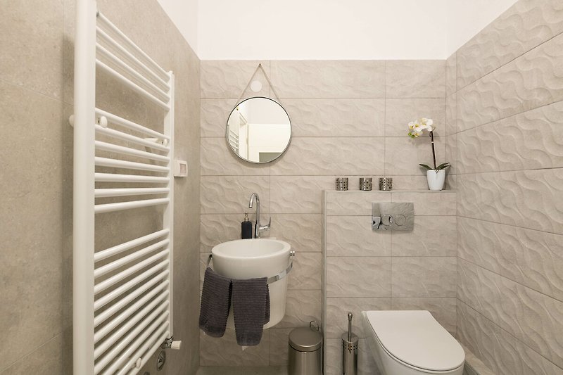 Schönes Badezimmer mit lila Beleuchtung, Spiegel und Waschbecken.