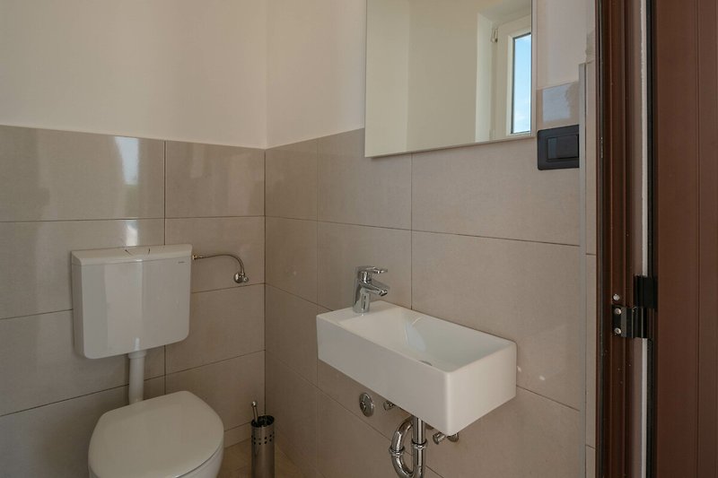 Schönes Badezimmer mit lila Beleuchtung und modernem Waschbecken.
