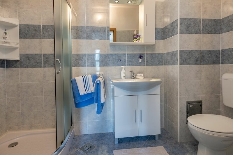 Ein modernes Badezimmer mit lila Waschbecken und Spiegel.
