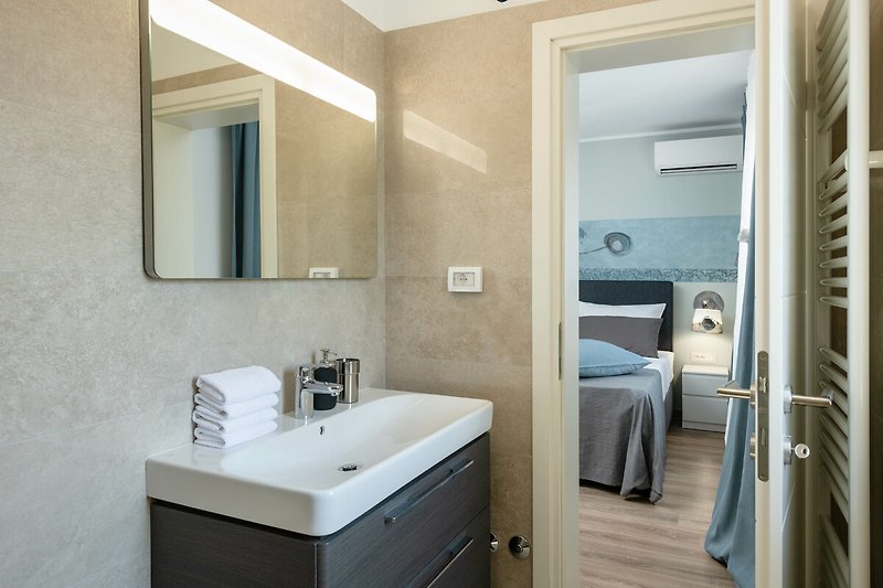 Schönes Badezimmer mit Holzmöbeln, Spiegel und Waschbecken.
