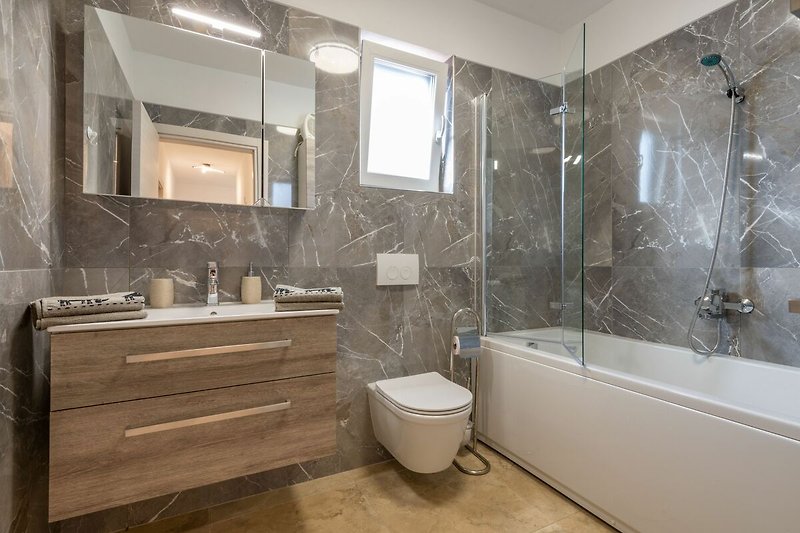 Das stilvolle Badezimmer bietet einen Rückzugsort zeitgenössischen Komforts.