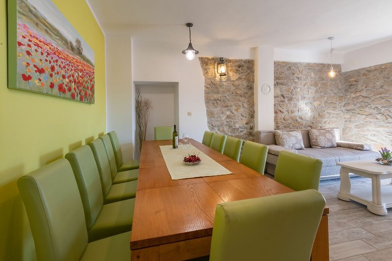 Die grünen, bequemen Stühle verleihen dem Essbereich der Villa Tupljak eine frische und angenehme Atmosphäre.