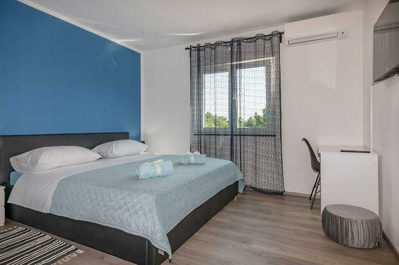 Das Schlafzimmer von Villa Rovena, geschmückt mit beruhigenden blauen Akzenten.
