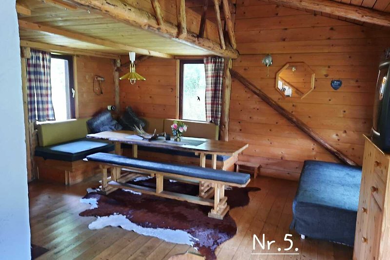 Gemütliches Wohnzimmer mit Holzmöbeln und Fensterblick.