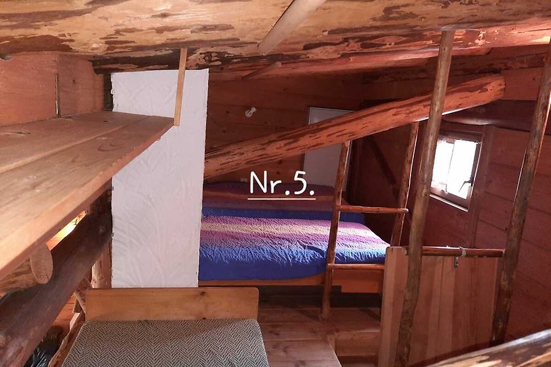 Gemütliche Holzdecke mit Balken und Holzboden in einem geräumigen Raum.