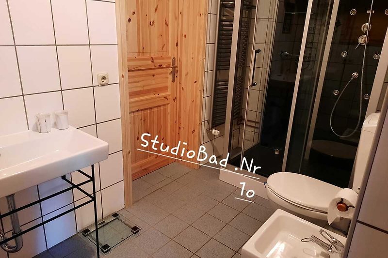 Ein modernes Badezimmer mit weißem Waschbecken und Keramikfliesen.