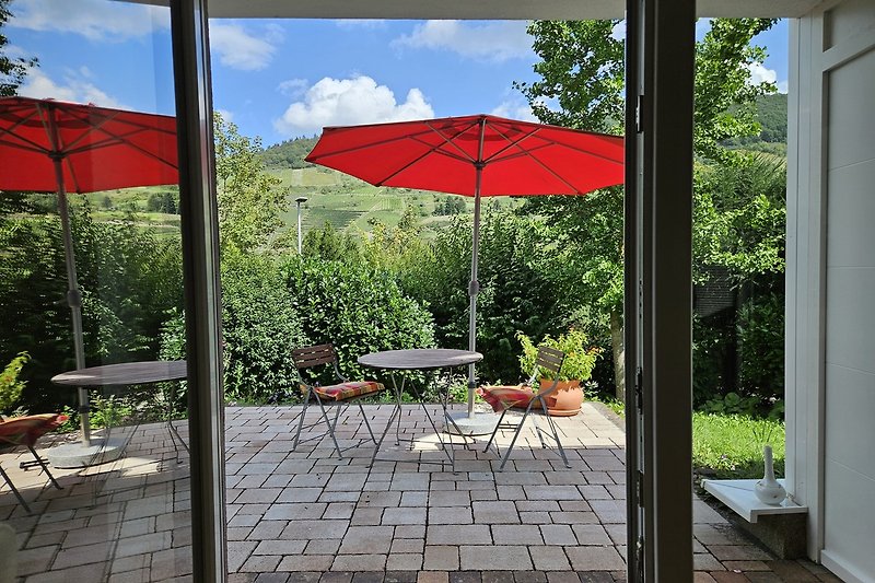 Einladende Terrasse mit bequemen Möbeln und grüner Umgebung.