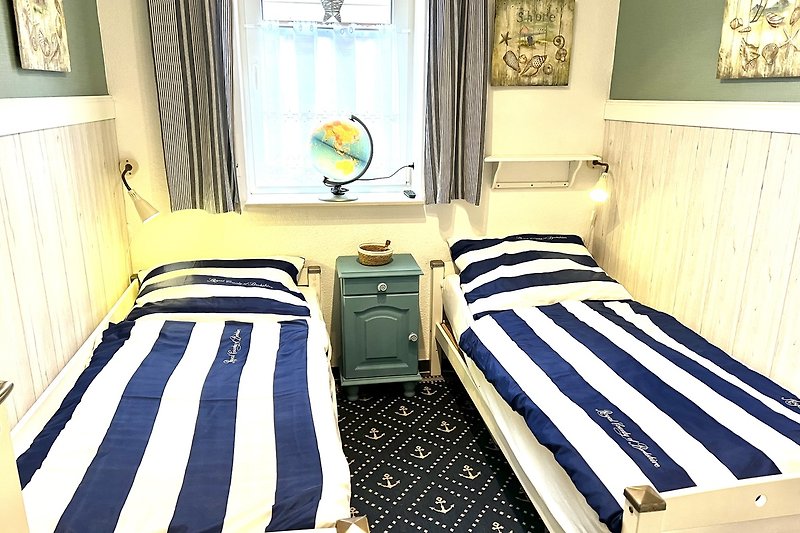 Stilvolles Schlafzimmer mit blauem Bett und gemütlicher Einrichtung.