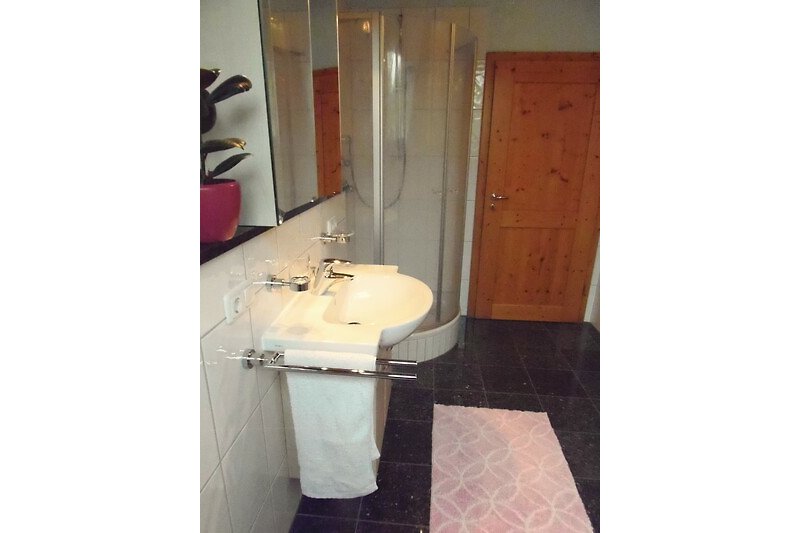 Modernes Badezimmer mit Spiegel und Marmorwaschbecken.