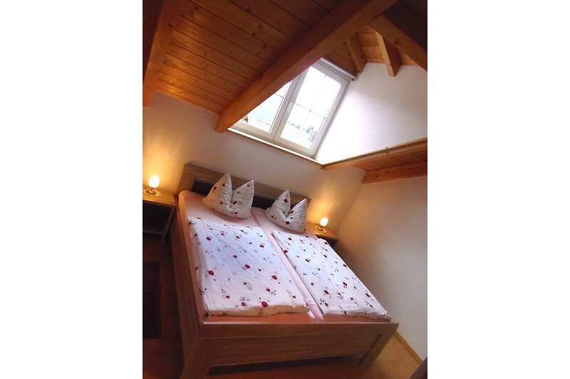 Gemütliches Schlafzimmer mit Holzmöbeln und Bett - perfekt zum Entspannen.