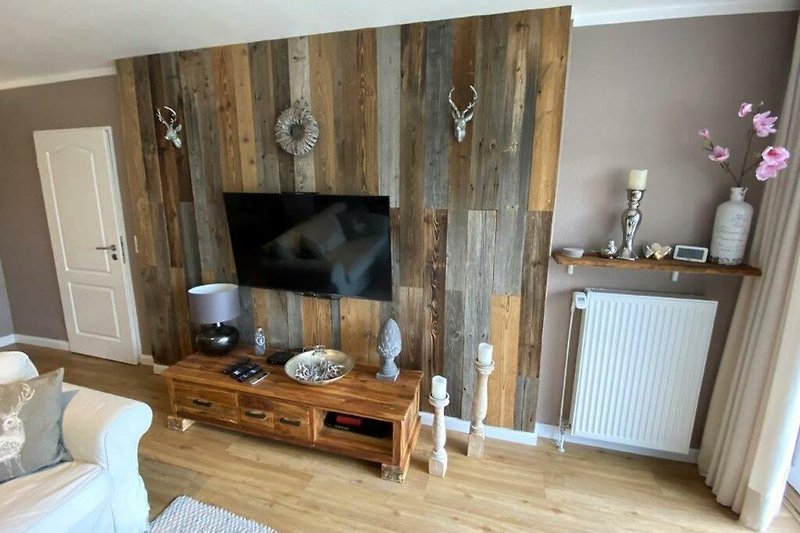 Wohnzimmer mit Holzmöbeln und Fernseher.