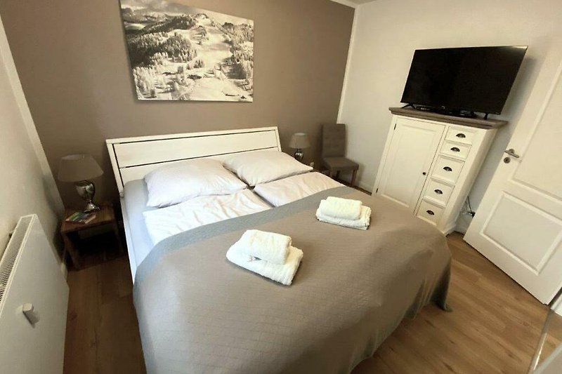Schlafzimmer mit Holzmöbeln und gemütlichem Bett.