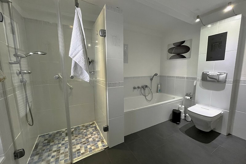 Ein modernens Badezimmer mit Fussbodenheizung,   ebenerdige  Dusche, Wanne  und WC