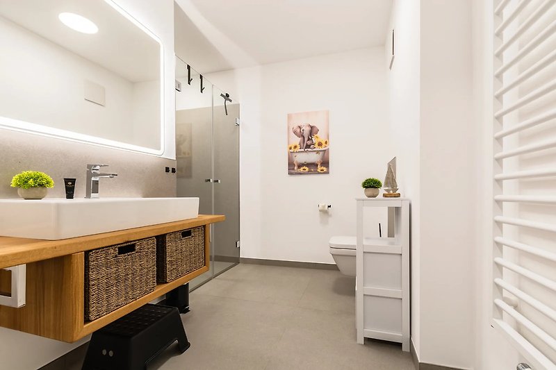 Modernes Badezimmer mit Holzmöbeln und stilvoller Beleuchtung.