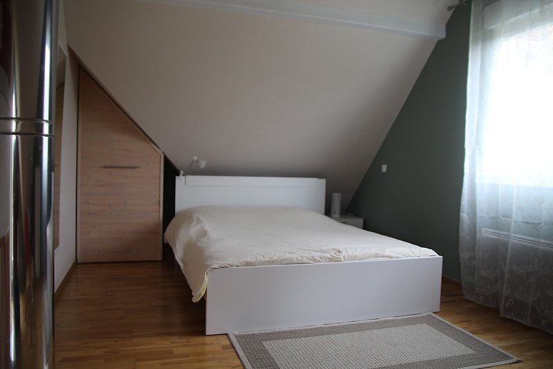 Schlafzimmer mit elegantem Bett und Vorhängen.