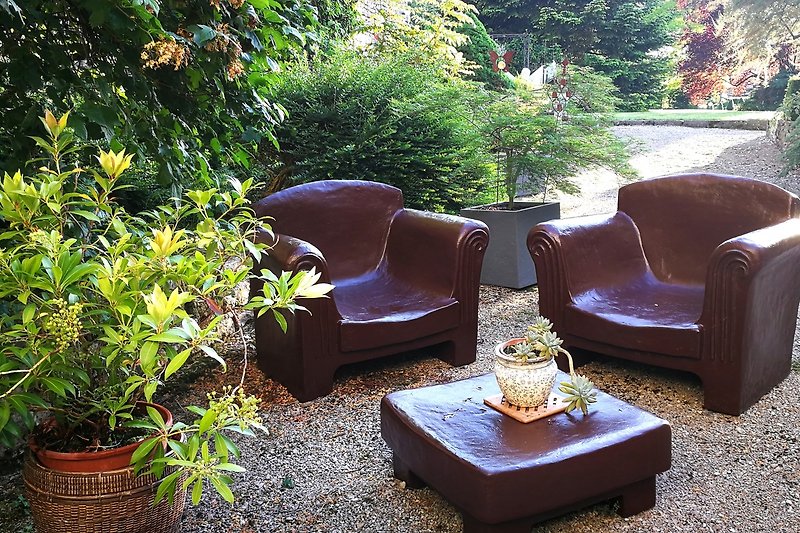 Gemütliche Terrasse mit Gartenmöbeln und blühenden Pflanzen.