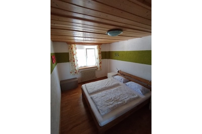 Gemütliches Schlafzimmer mit Holzbett und stilvollem Interieur.