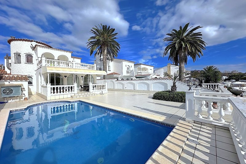 Luxuriöse Villa mit Pool, Palmen und Meerblick im tropischen Paradies.