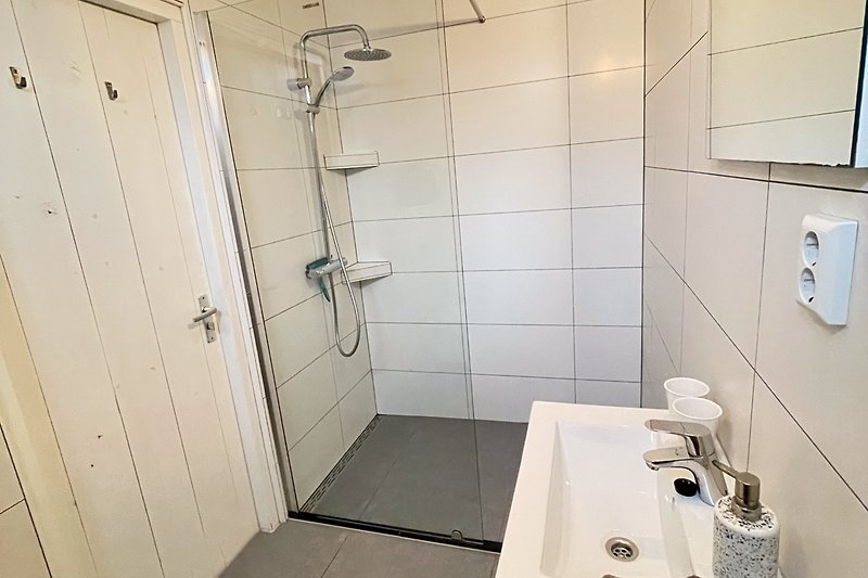 Modernes Badezimmer mit stilvoller Dusche und elegantem Waschbecken.